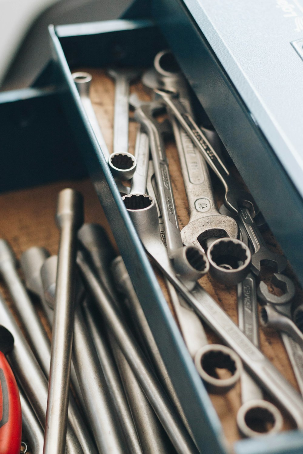 Clés et douilles rangées dans une caisse à outils métallique.